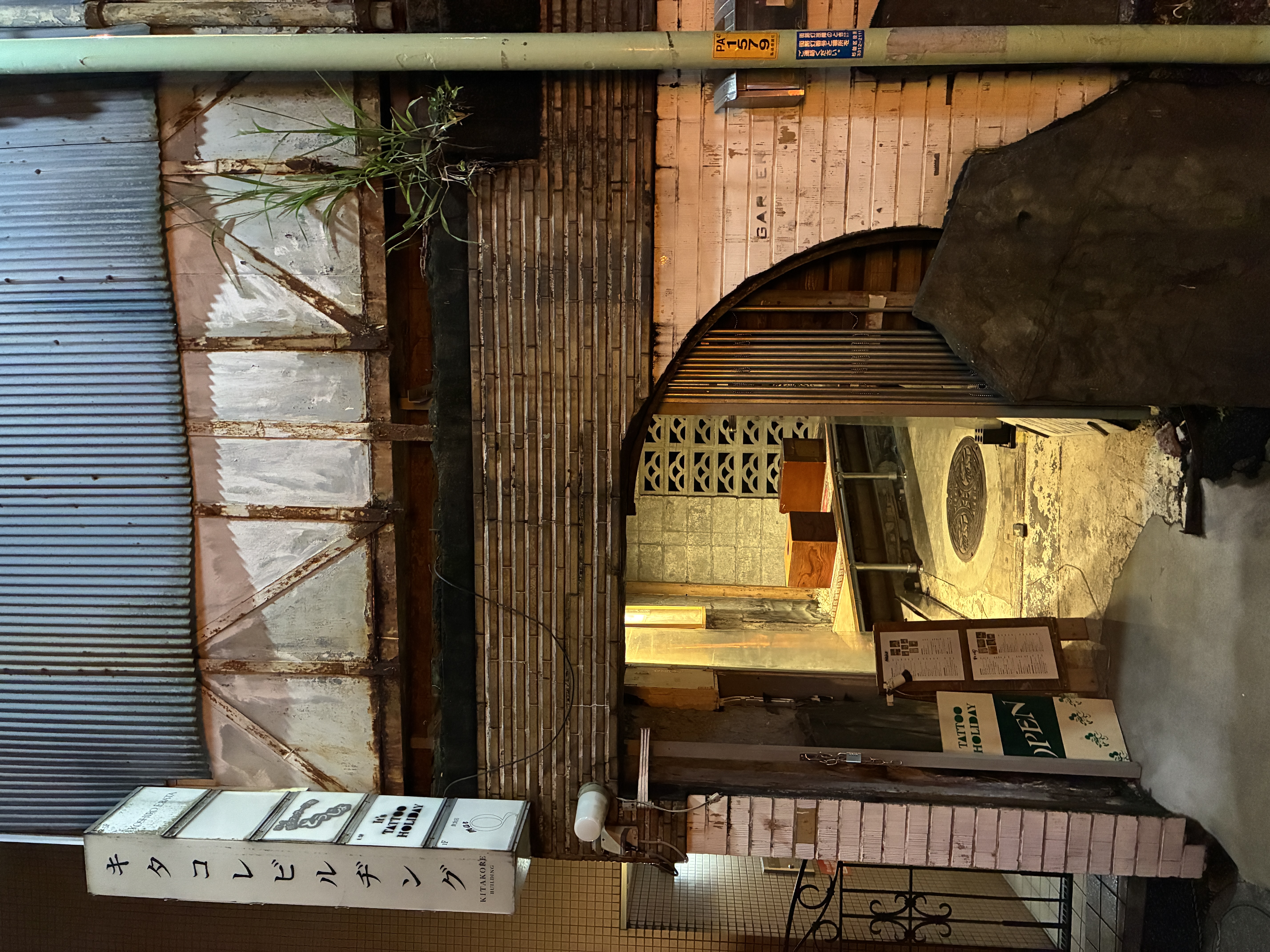 キタコレビルヂングの看板と丸い開口部のある入口